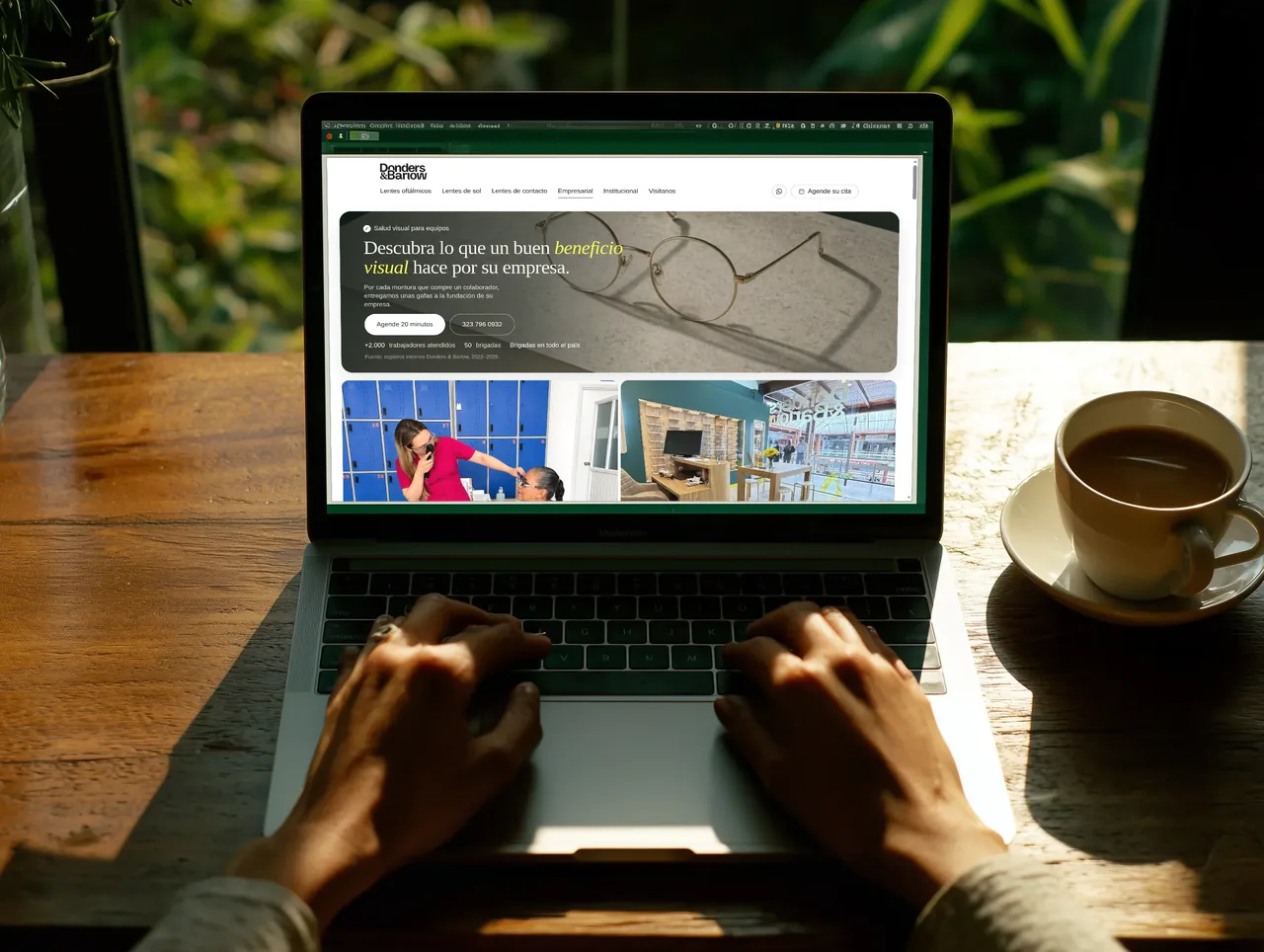 Persona con una laptop en una mesa de madera; la pantalla muestra don.bar/empresas, con la ciudad de noche al fondo